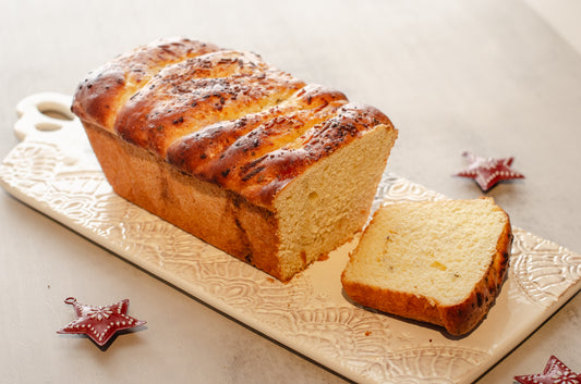 Golden garlic parmesan butter bread loaf with a slice cut, on a decorative cutting board with star-shaped ornaments., baked fresh by Chillable Bake Shop in Darien, Wisconsin.