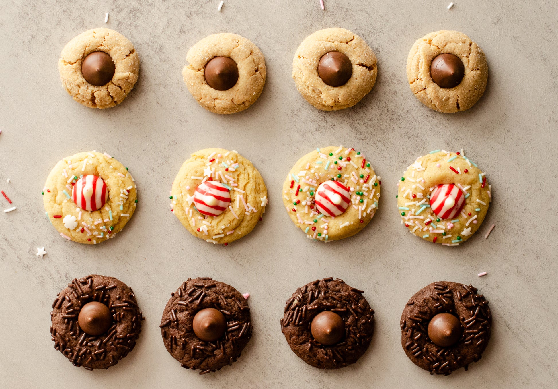 Assorted Holiday Blossom Cookies with chocolate kisses and candy decorations on a textured surface, baked fresh in Darien, WI by Chillable Bake Shop.