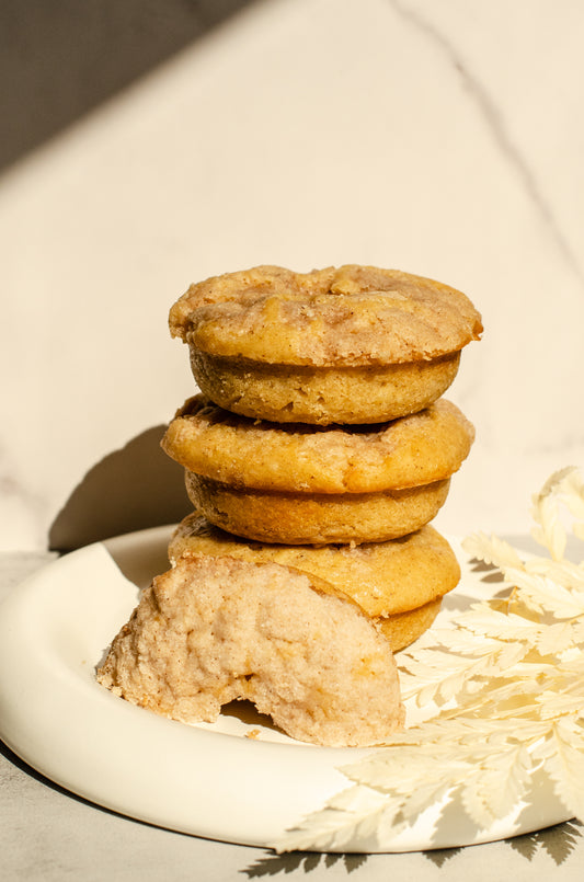 Stack of baked coffee cake donuts with cinnamon crumble topping on a plate with a neutral background, fresh-baked from Chillable Bake Shop in Darien, Wisconsin.